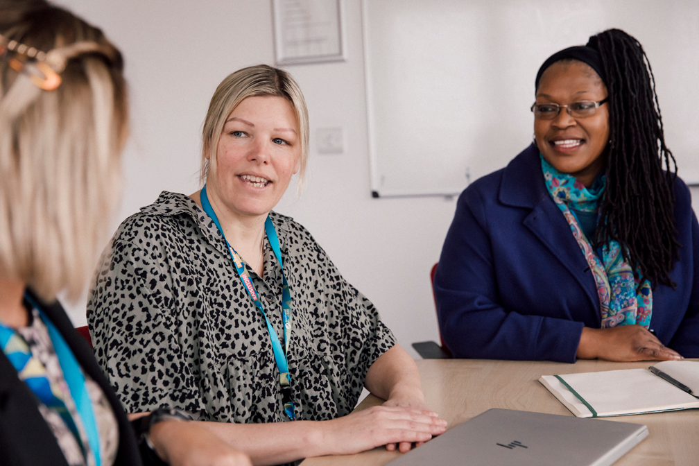 Female colleagues chatting together at work in a meeting